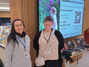 Harjoittelijat Anne Immonen ja Mona Hörman infotaulun edessä