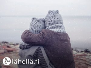 Joulukuussa kampanjoidaan yksinäisyyttä vastaan (kuvassa lapset istuvat rannalla harmaassa säässä ja halaavat)